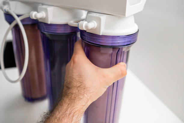 Man hand opens the reverse osmosis system for water purification at home